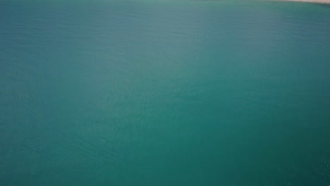 Luftaufnahme-Des-Türkisfarbenen-Wassers,-Das-Sich-Zur-üppigen-Insel-Mit-Sandstrand-In-Thailand-Neigt