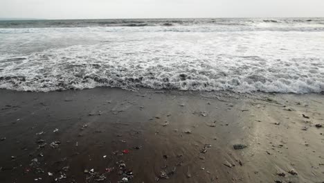 Zeitlupenaufnahme,-Während-Wellen-Müll-Aus-Dem-Meer-An-Den-Strand-Von-Bali-Spülen