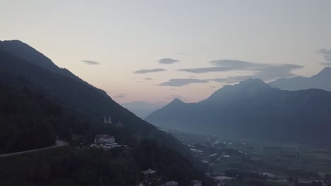 Aerial-view-of-Levico-Terme,-Italy-during-sunrise-with-drone-flying-forward