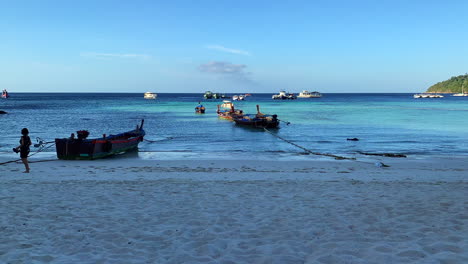 12-seconds-time-lapse-of-a-beach-line-in-the-early-morning-with-blue-sky-and-long-tail-boats-in-the-background