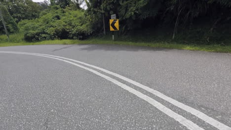Driving-down-a-windy-road-with-sharp-turn-on-left-side-in-Malaysia