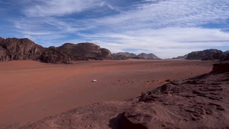 Ein-Zeitraffer-Der-Wadi-Rum-Wüstenebene-Mit-Hin-Und-Her-Fahrenden-Autos