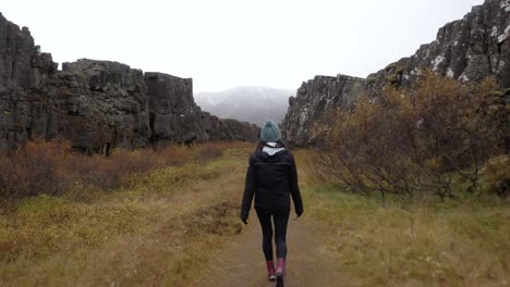 Mujer-Joven-Caminando-En-Un-Cañón-Islandés---Ancho