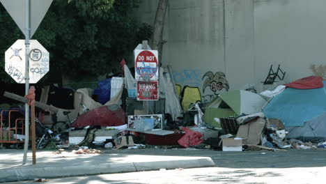 Wide-shot-as-the-camera-pans-across-a-homeless-encampment-near-a-freeway-overpass