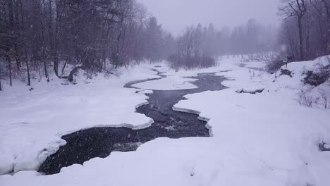 SLOW-MOTION-shot-of-two-icy-streams-converging-during-a-winter-snowstorm