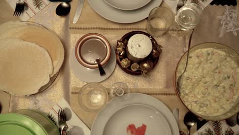 Overhead-left-slow-motion-slide-over-richly-decorated-Christmas-dinner-table