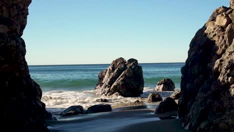 Slowmo-Wellen-Krachen-Gegen-Hervorstehende-Felsen-In-Malibu,-Kalifornien