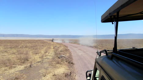 Vista-Desde-El-Techo-De-Un-Vehículo-De-Safari-Conduciendo-Por-Un-Camino-De-Tierra-En-El-Serengeti