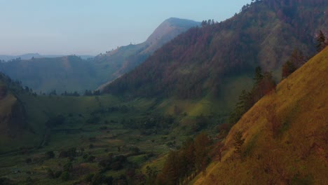Pullback-aerial-drone-footage-of-the-lush-cliffs-and-valleys-at-dusk-in-the-Karo-Regency,-North-Sumatra,-Indonesia