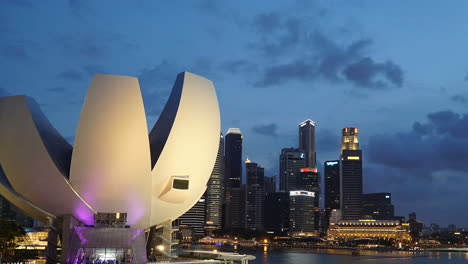 Singapur---Circa-Stadtsonnenuntergang-Im-Zeitraffer-Mit-Gebäuden,-Türmen,-Meer-Und-Buntem-Himmel