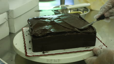 Adding-Chocolate-Icing-On-Top-Of-A-Chocolate-Cake
