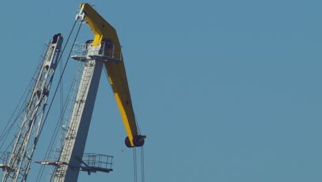 Sea-port-crane-in-sunny,-warm-day,-telephoto-medium-closeup-shot-from-distance