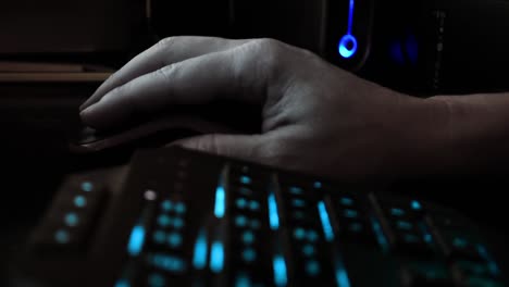 Cerrar-La-Mano-De-Un-Hacker-Usando-Un-Ratón-De-Computadora,-Oficina-Oscura