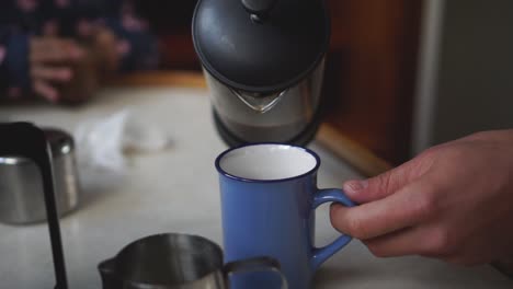 SLOWMO---Pouring-fresh-black-coffee-from-french-press-into-blue-ceramic-cup