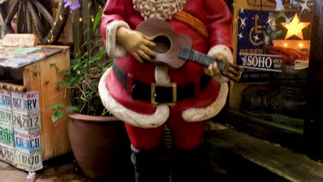 Statue-of-Santa-Celebrating-Christmas-Outside-a-Store-in-American-Village,-Okinawa,-Japan