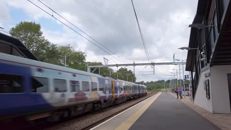 Panning-Shot-of-a-Northern-Train-Passing-Through-a-Commuter-Station-in-the-Outskirts-of-Leeds-in-Slow-Motion