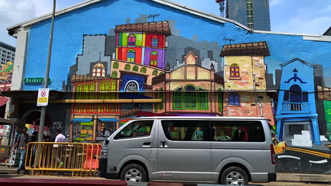 Footage-of-an-art-painted-and-display-on-the-wall-of-a-shop-house-along-the-street-with-a-mini-van-or-vehicle-park-on-the-side-of-the-street