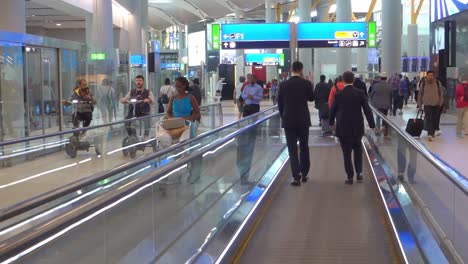 People-in-transit-on-a-moving-walkway-on-new-Istanbul-airport,-Turkey