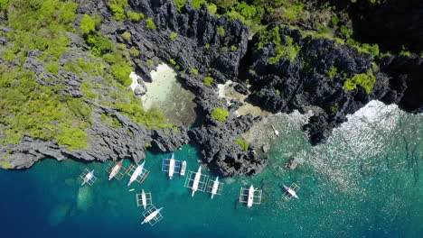 Luftaufnahme-Einer-Versteckten-Lagune-Mit-Vielen-Geparkten-Spinnenbooten,-Coron,-Palawan,-Philippinen
