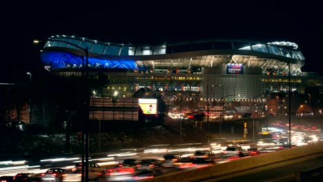 Zeitraffer-Des-Verkehrsflusses-Auf-Der-Autobahn-I25-Vor-Dem-Hintergrund-Des-Kilometerhohen-Stadions-Von-Denver-Broncos