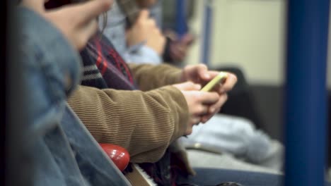 Nahaufnahme-Von-Menschen,-Die-Mit-Ihrem-Smartphone-In-Der-U-Bahn-Sitzen
