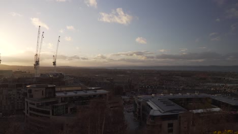 Schwenkaufnahme-Vom-Calton-Hill-Mit-Blick-Auf-Die-Stadt-Edinburgh,-Schottland,-Mit-Schönem-Sonnenuntergangslicht-Und-Wolken-Und-Dem-Atlantischen-Ozean-Im-Hintergrund
