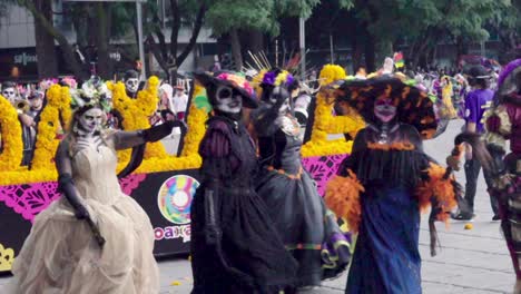 Day-of-the-dead-parade,-las-calaveras-in-skull-costume-and-mexican-man-with-sombrero-are-dancing-in-slow-motion-60-FPS
