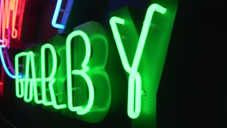 Close-shot-of-green-neon-in-a-dark-room-in-slow-motion