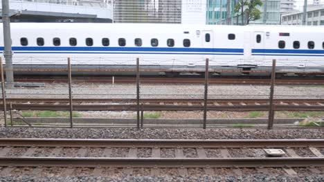 Blick-Auf-Den-Shinkanzen-Hochgeschwindigkeitszug,-Während-Er-Am-Bahnhof-In-Tokio,-Japan,-Vorbeifährt-–-Tagsüber-Vom-Bahnsteig-Aufgenommen-–-4K-UHD-Videofilmmaterial,-Kurz