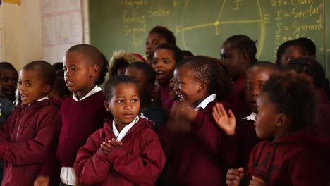 Afrikanische-Kinder-Singen-Und-Klatschen-Während-Des-Unterrichts-Im-Klassenzimmer