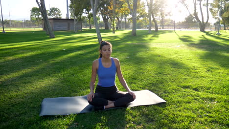 A-young-woman-doing-yoga-in-meditation-pose-in-nature-at-sunrise-to-reduce-anxiety-and-stress