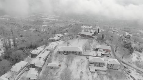 Luftaufnahmen-über-Schneebedeckten-Bergen,-Traditionelles-Dorf-In-Griechenland-4
