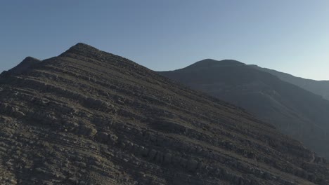 Tiro-De-Drone-De-Una-Colina-De-Montaña-Rocosa-En-La-Hora-Dorada