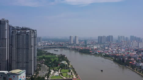 Luftaufnahme-Des-Saigon-Flusses,-Der-An-Einem-Klaren,-Sonnigen-Tag-An-Neuen-Wohnhäusern-In-Binh-Thanh-In-Richtung-Thao-Dien-Vorbeifliegt