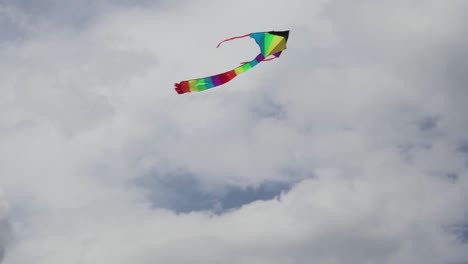Colorful-kite-flying-against-blue-sky-with-clouds