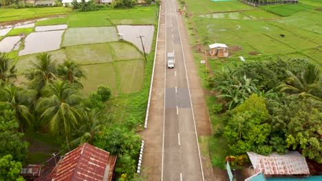 Drohnenaufnahmen-Von-Reisfeldern-Und-Straßen-Mit-Autos-In-Einem-Kleinen-Dorf-Auf-Den-Philippinen-4k