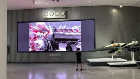 Boy-watching-a-digital-art-display-at-an-automotive-museum-in-Los-Angeles,-California