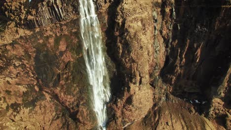 Wasserfall-In-Island-An-Einem-Sonnigen-Tag,-Wasser-Fällt-Von-Einer-Felsigen-Klippe
