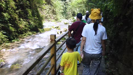 Zhangjiajie,-China---August-2019-:-Mother-and-her-child-walking-on-the-scenic-pathway-along-the-green-river-flowing-through-the-majestic-Grand-Canyon-in-Zhangjiajie-National-Park