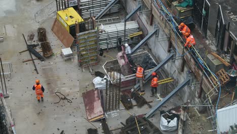 Trabajadores-De-La-Construcción-Poniendo-Basura-En-El-Contenedor-En-Nueve-Millbank,-Westminster