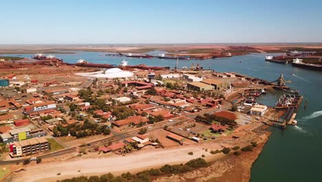 Circling-aerial-shot-of-working-port-town,-Port-Hedland,-Western-Australia