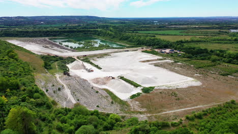 Rising-aerial-landscape-of-a-chalk-and-lime-quarry,-on-a-bright-summers-day