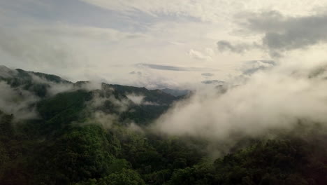 Aerial-view-flying-thru-the-morning-rain-cloud-covered-tropical-rain-forest-mountain-landscape-during-the-rainy-season-on-the-Doi-Phuka-Mountain-reserved-national-park-the-northern-Thailand
