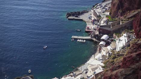 View-from-above-to-a-small-dock-with-boats-in-the-aegean-sea,-Santorini,-Greece