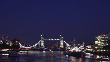 Night-view-of-Tower-Bridge-in-London-with-boat-on-Thames-river,-beautiful-background