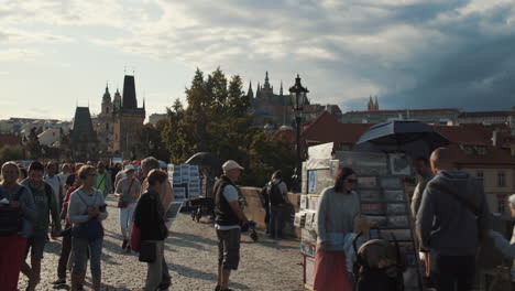 Asian-Girl-passing-and-walking-with-tourists-on-Charles-Bridge,-Prague,-Czech-Republic