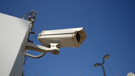 Nahaufnahme-Weiße-Überwachungskamera-Mit-Blauem-Himmel-Im-Hintergrund