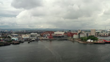 Aerial-Flyover-of-Cardiff-Bay-Pulling-Back-from-the-Quayside-on-a-Cloudy-Summer’s-Day-with-Passenger-Ferry---Sailboat-in-Foreground
