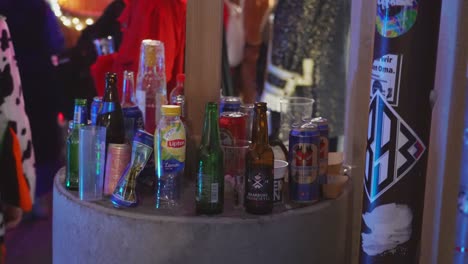 Zoom-out-shot-of-many-empty-bottles-of-alcohol-during-costume-party-in-nightclub
