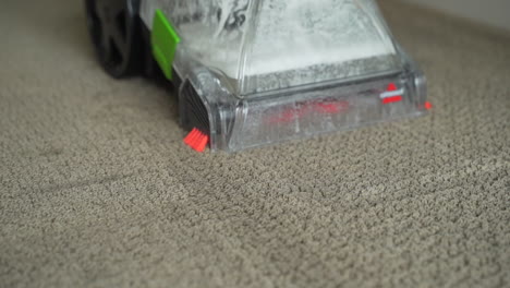 Close-up-view-of-Bissell-deep-cleaner-shampooing-carpet-in-a-home